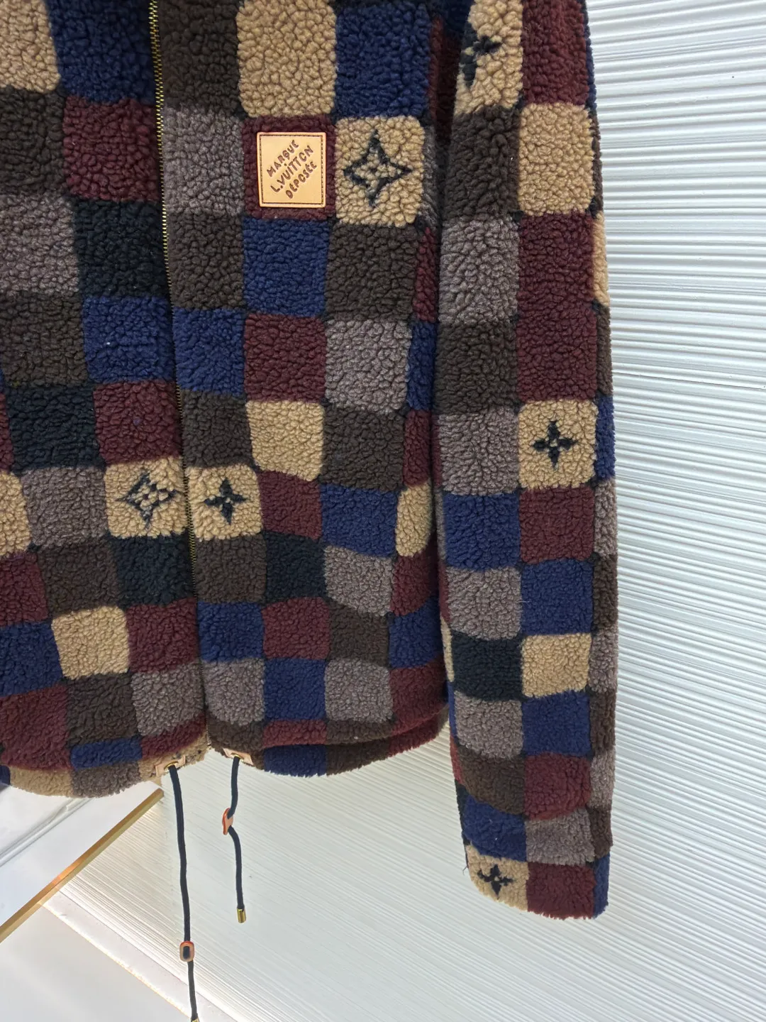 LOUIS VUITTON colorful checkerboard jacket ●Original version: Purchased and developed for 16500 ●Item number: 1682292-B95 ●Fabric: Fleece fabric ●Technology: Jacquard production ●Color: Color ●Version: Fitted version ●Weight: about 700 grams ●Size: XS-S-M-L ●Description: The main body of this Louis Vuitton satin baseball jacket is made of high-density matte satin fabric, which has been treated with anti-wrinkle shaping technology. The fabric has a strong drape and is not easy to wrinkle. The dark brown background color is prepared by precision dyeing and finishing technology, giving it a rich color and high-end texture. The "L.V.M SINCE 1854" logo on the left chest is made with hot-drilling technology. High-quality rhinestones are used for precise hot-pasting in different areas. The diamond surface is shiny and strong and will not fall off easily. The ribbed splicing of the collar, cuffs and hem is a three-color contrasting design. It is woven with high-elastic knitted yarn, which will not easily loosen and deform after long-term wear. The placket is equipped with custom-made metal snaps. The hardware is thick and anti-oxidation. The overall style is loose and off-shoulder. The splicing is covered with blind stitching technology, and the wiring is smooth and traceless. Every craft detail follows the brand's luxury product production standards, taking into account both design and wearing comfort. The overall wiring is straight and delicate, the fabric is comfortable and soft, and the color is consistent without color difference. It can be matched with the same style to create a fashionable look and control various occasions. Customized accessories, complete with three standards, same style for men and women!